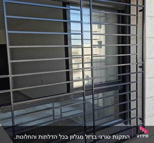 חלון עם סורגים מתכתיים על קיר אבן
